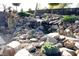 Landscaped backyard with a stone waterfall feature at 4270 Victoria Ln, Avon, IN 46123