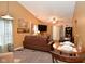 Spacious living room with a brown leather sofa, a large TV, and a dining area at 10722 Lostpine Ln, Indianapolis, IN 46235