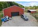 Red barn with a black garage door and a gray SUV parked in front at 4525 S Deck Rd, Gosport, IN 47433