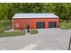 Red barn with two black garage doors and one entry door at 4525 S Deck Rd, Gosport, IN 47433