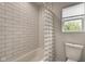 Clean bathroom with subway tile, shower/tub combo, and window at 1229 N Keystone Ave, Indianapolis, IN 46201