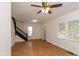 Living room with hardwood floors, ceiling fan, and black staircase at 309 N Lasalle St, Indianapolis, IN 46201