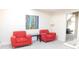Small sitting area with two red armchairs and a glass table at 10781 Cedar Ridge Ln, Brownsburg, IN 46278