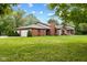 Brick ranch home with attached two-car garage and lush green lawn at 9263 Golden Oaks W, Indianapolis, IN 46260