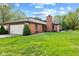 Brick ranch home with attached two-car garage and manicured lawn at 9263 Golden Oaks W, Indianapolis, IN 46260