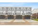 Rear exterior of townhomes, with gray siding and attached garages at 7306 W County Road 600 Rd # 14-602, McCordsville, IN 46055