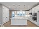 Spacious white kitchen with a large island, pendant lights, and stainless steel appliances at 7306 W County Road 600 Rd # 14-602, McCordsville, IN 46055