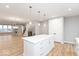 Modern kitchen open to the living room, featuring a large island and light wood floors at 7306 W County Road 600 Rd # 14-602, McCordsville, IN 46055