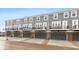 Rear view of townhouses with gray siding, balconies, and attached garages at 7310 W County Road 600 Rd # 14-603, McCordsville, IN 46055