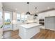 Modern white kitchen with large island, stainless steel appliances, and wood-look flooring at 7310 W County Road 600 Rd # 14-603, McCordsville, IN 46055