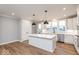 Bright, white kitchen with island, pendant lights, and stainless steel appliances at 7310 W County Road 600 Rd # 14-603, McCordsville, IN 46055