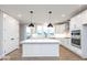 White kitchen featuring an island, stainless steel appliances, and ample natural light at 7310 W County Road 600 Rd # 14-603, McCordsville, IN 46055