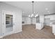 Bright dining area with hardwood floors and a chandelier, leading to the kitchen at 10618 Maidenhair Dr, Indianapolis, IN 46239