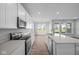 Modern kitchen with white cabinets, an island, and stainless steel appliances at 10618 Maidenhair Dr, Indianapolis, IN 46239