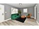 Cozy living room featuring a green velvet couch and wood-look floors at 2035 N Tibbs Ave, Indianapolis, IN 46222