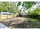 Large backyard with mature trees and wooden fence at 2035 N Tibbs Ave, Indianapolis, IN 46222