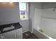 Bathroom with gray vanity, white tub, and a single window at 3544 Wrangler Dr, Bargersville, IN 46106