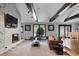 Living room with stone fireplace, hardwood floors, and large windows at 8954 Briarclift Rd, Indianapolis, IN 46256