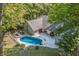 Aerial view of house, in-ground pool, deck, and surrounding woods at 8954 Briarclift Rd, Indianapolis, IN 46256