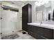 Modern bathroom with a walk-in shower, dark vanity, and gray tile at 6129 Crittenden Ave, Indianapolis, IN 46220