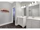 Bathroom with double vanity, white cabinets, and dark hardwood floors at 6129 Crittenden Ave, Indianapolis, IN 46220