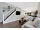 Living room with hardwood floors, sectional sofa, and stairs to the upper level at 6129 Crittenden Ave, Indianapolis, IN 46220