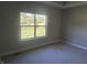 Simple bedroom with gray walls, carpeted floors, and a large window at 1230 Thorndon Ct, Danville, IN 46122
