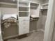 Bright walk-in closet with white shelves, drawers and rods at 1230 Thorndon Ct, Danville, IN 46122