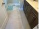 Bathroom with dark brown vanity, light gray tile floor, and a shower at 1230 Thorndon Ct, Danville, IN 46122