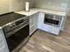Modern kitchen with stainless steel appliances, white cabinets, and wood-look flooring at 1230 Thorndon Ct, Danville, IN 46122