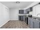 Eat-in kitchen featuring gray cabinets and wood-look vinyl flooring at 1526 Lawton Ave, Indianapolis, IN 46203