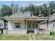 Charming bungalow features a white exterior, covered porch, and landscaped yard at 712 W Queen St, Muncie, IN 47303