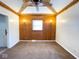 Bedroom with wood paneled walls and ceiling fan at 712 W Queen St, Muncie, IN 47303