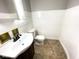Clean bathroom with white sink and toilet, and wood-paneled walls at 712 W Queen St, Muncie, IN 47303