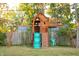 Charming backyard with a wooden playset, swings, and slide at 6205 Bramshaw Rd, Indianapolis, IN 46220