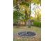 Landscaped backyard with mature trees and a fire pit at 6205 Bramshaw Rd, Indianapolis, IN 46220