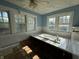 Bathroom with a built-in bathtub, three windows, and light blue walls at 548 Central N Ct, Indianapolis, IN 46205