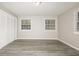 Bedroom with gray vinyl flooring, white closet doors and two windows at 3226 W 46Th St, Indianapolis, IN 46228