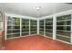Empty screened porch with red floor and view of the backyard at 3226 W 46Th St, Indianapolis, IN 46228
