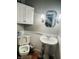 Clean bathroom with pedestal sink, toilet and white wood cabinets at 4839 Alameda Rd, Indianapolis, IN 46228