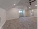 Large bonus room with grey carpeting, ceiling fan, and multiple windows at 1521 Indiana Ave, Columbus, IN 47201