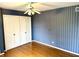 Simple bedroom with wood floors, ceiling fan, and blue striped wallpaper at 7722 Shady Hills W Dr, Indianapolis, IN 46278