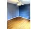 Empty bedroom featuring hardwood floors and blue patterned walls at 7722 Shady Hills W Dr, Indianapolis, IN 46278