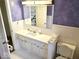 Bathroom with vanity, mirror, and purple walls at 7722 Shady Hills W Dr, Indianapolis, IN 46278