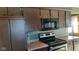 Dark wood cabinets, microwave, and electric range in this kitchen at 2721 Del Prado Dr, Indianapolis, IN 46227