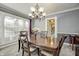 Elegant dining room with a wood table, chandelier, and large windows at 6502 Allisonville Rd, Indianapolis, IN 46220