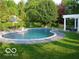 Stunning kidney-shaped pool surrounded by lush landscaping and a pergola-covered patio at 9510 Copley Dr, Indianapolis, IN 46260