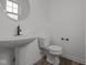 Modern bathroom with pedestal sink, toilet and dark-colored hardware at 4231 Barrel Ln, Westfield, IN 46062