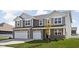 Two story home with gray siding and brick accents, two-car garage at 6429 Flag Stop Dr, Whitestown, IN 46075