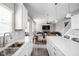 Open kitchen with white cabinets, island, and views to living room and dining area at 6429 Flag Stop Dr, Whitestown, IN 46075